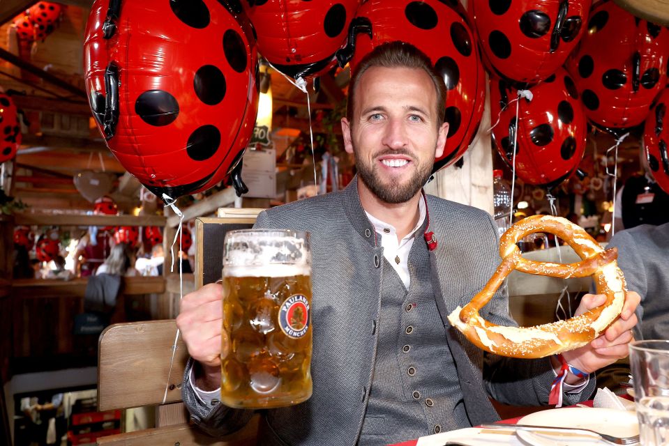 a man holding a beer mug that says paulaner on it