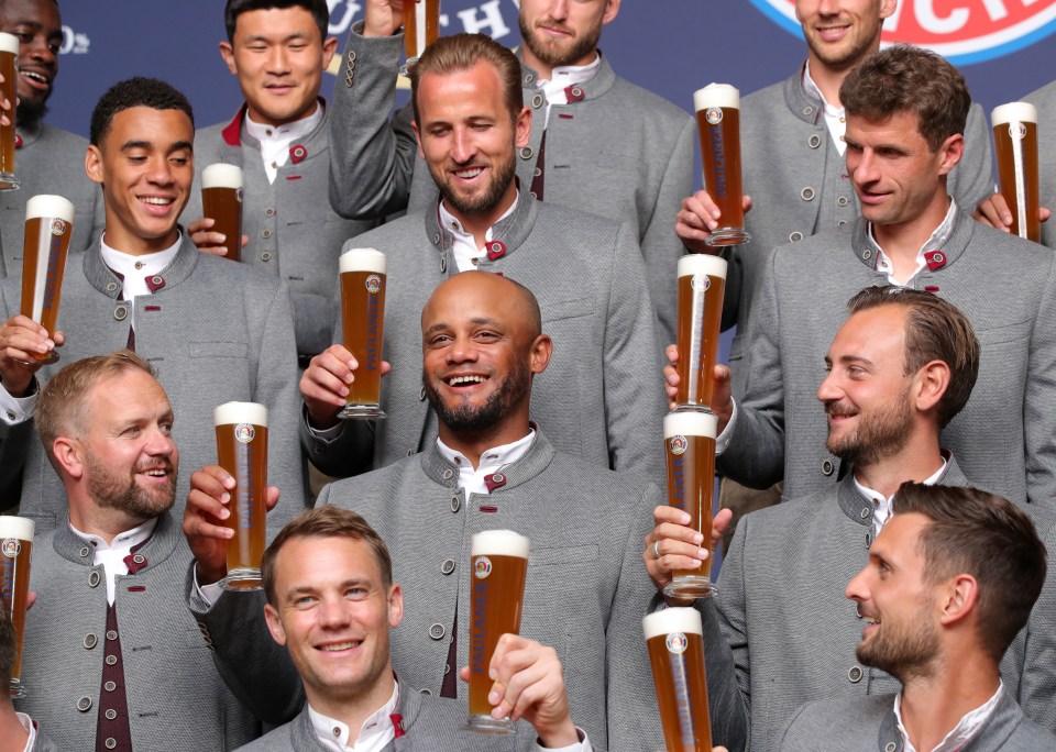 a group of men are holding up glasses of beer that say ' bayern ' on them