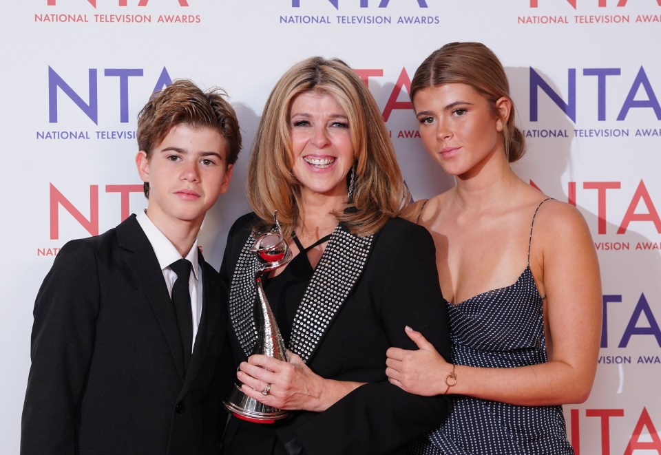 a woman and two children pose in front of a wall that says national television awards