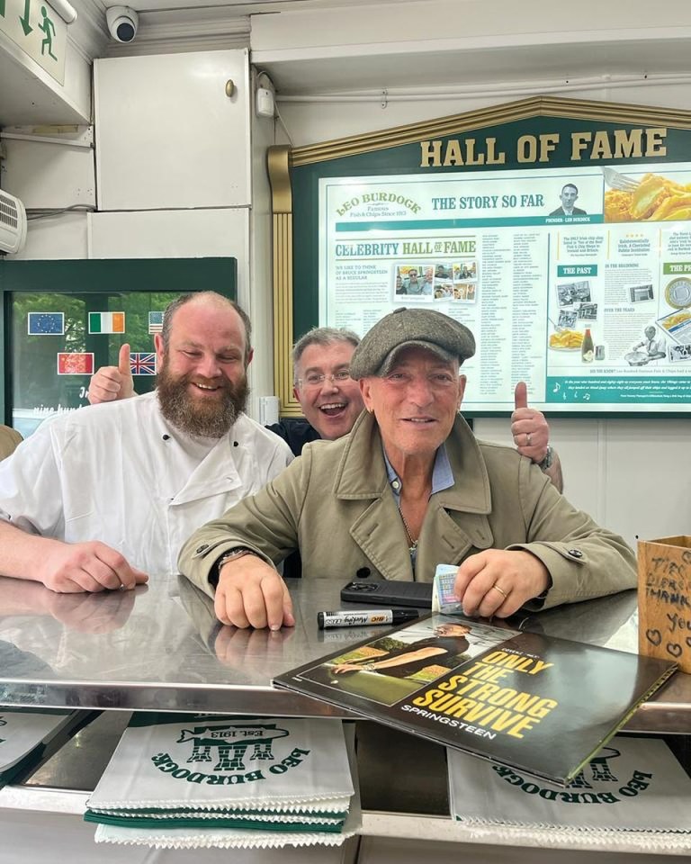 three men are posing for a picture in front of a sign that says hall of fame