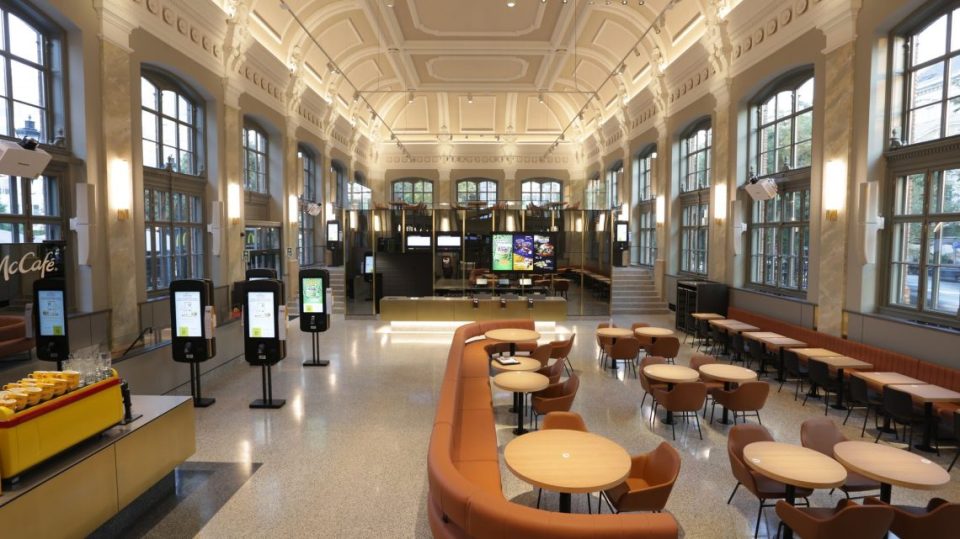 a large room with tables and chairs and a sign that says mccafe
