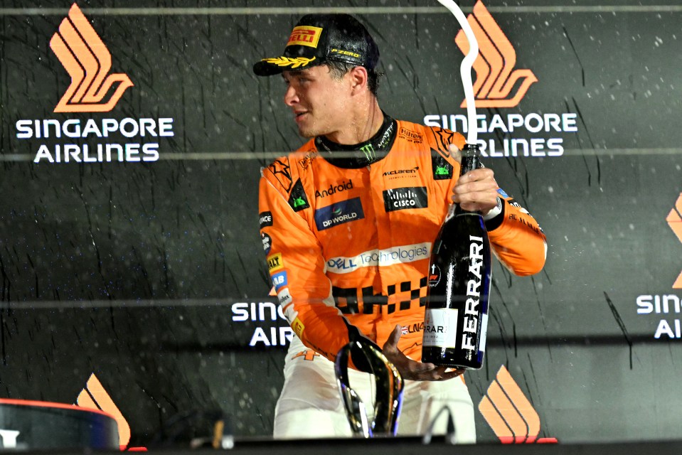 a man holding a bottle of ferrari champagne in front of singapore airlines