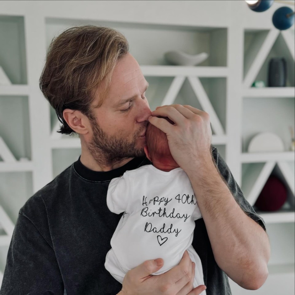 a man kisses a baby whose shirt says happy 40th birthday daddy