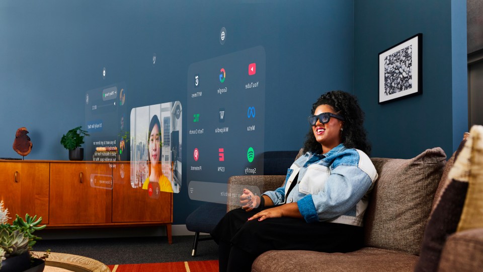 a woman sits on a couch in front of a screen that says ' spotify ' on it