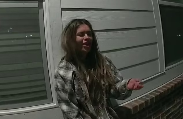 a woman in a plaid shirt is standing in front of a building .