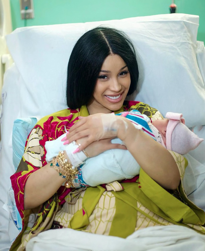 a woman is holding a baby in a hospital bed