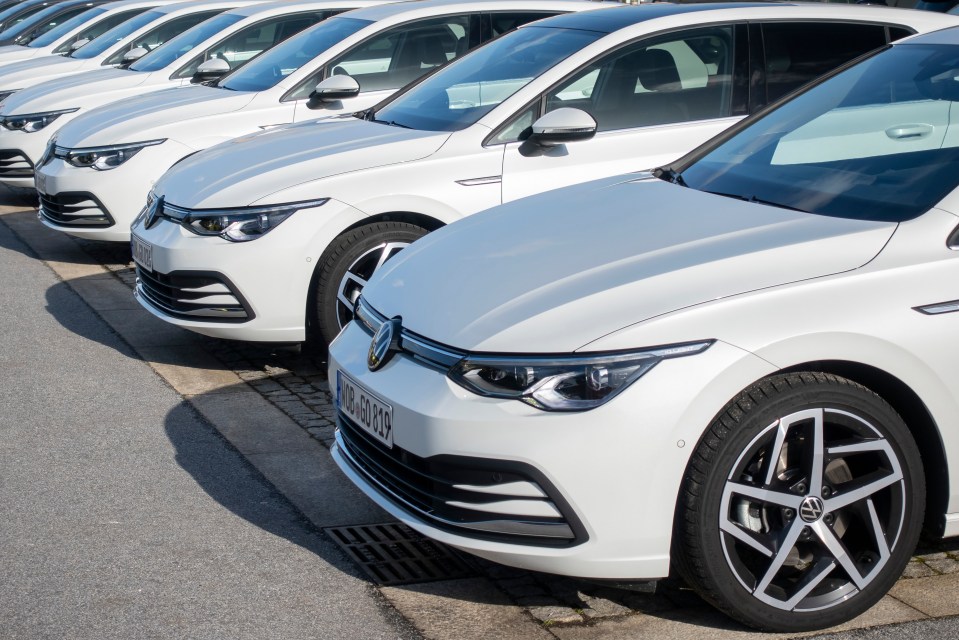 a row of white volkswagen cars are parked in a row