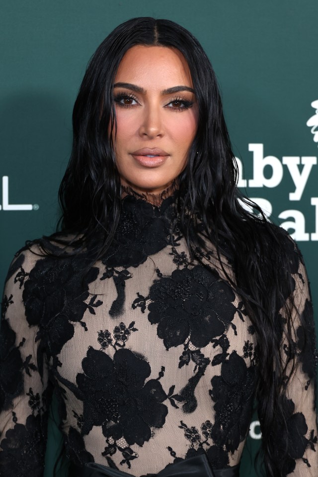 a woman with long black hair is standing in front of a sign that says baby