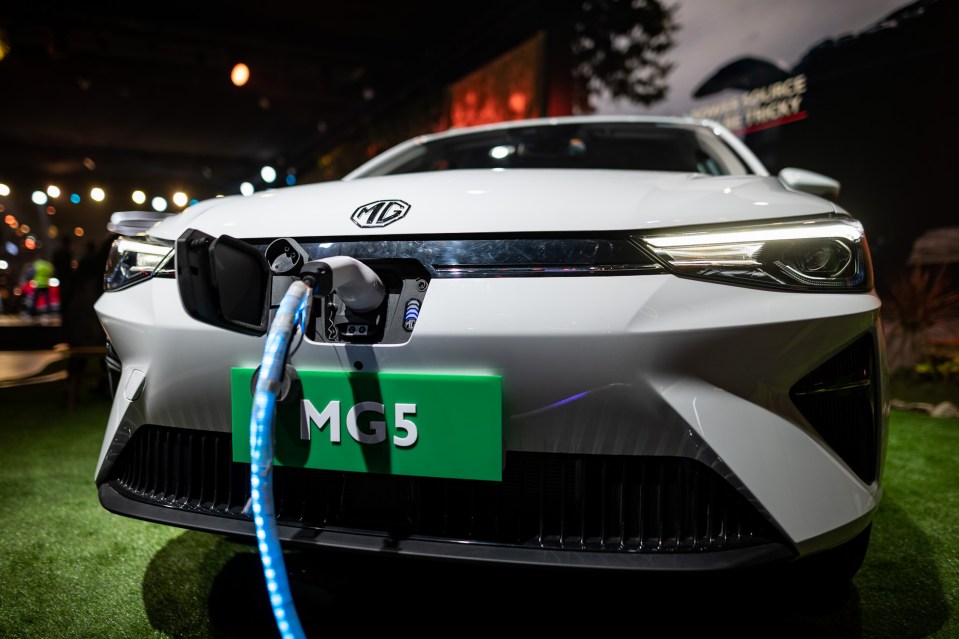 a white mg car is plugged into a charging station
