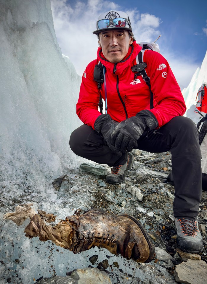 a man in a red north face jacket kneeling down