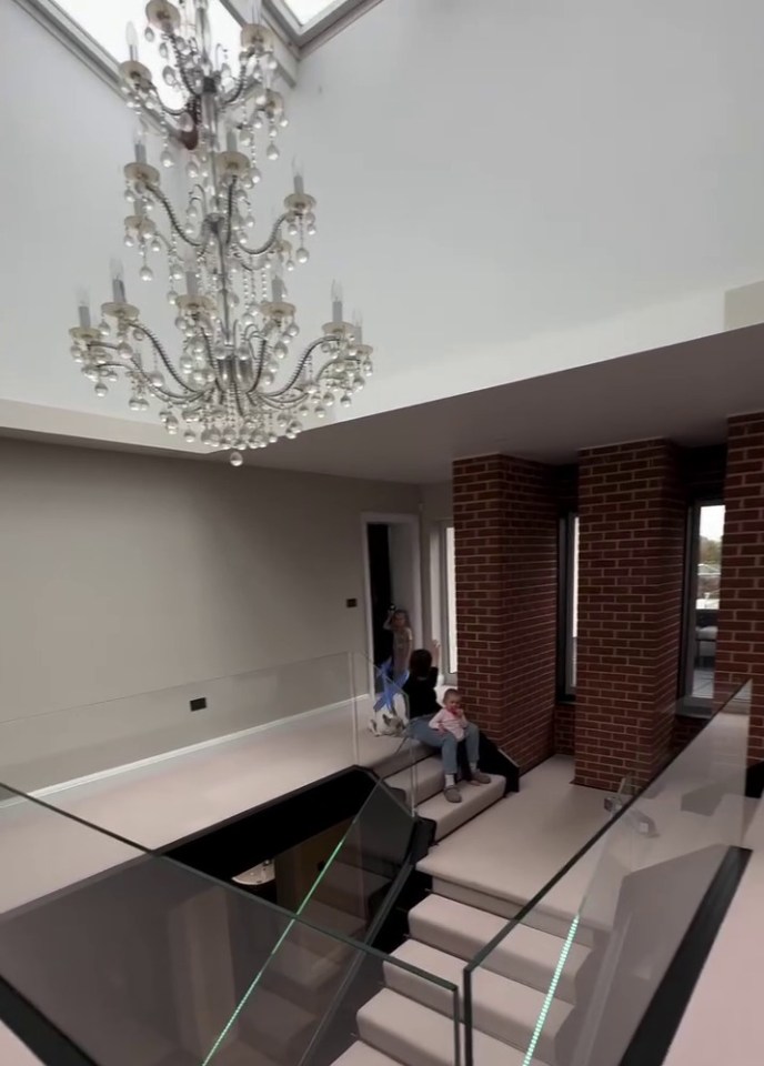 a chandelier hangs from the ceiling above a set of stairs