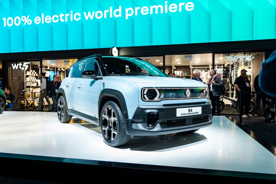 a white car is on display in front of a sign that says 100 % electric world premiere