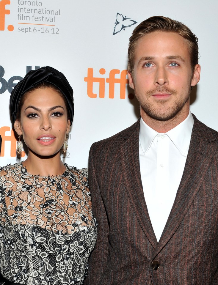 a man and woman pose in front of a toronto international film festival sign