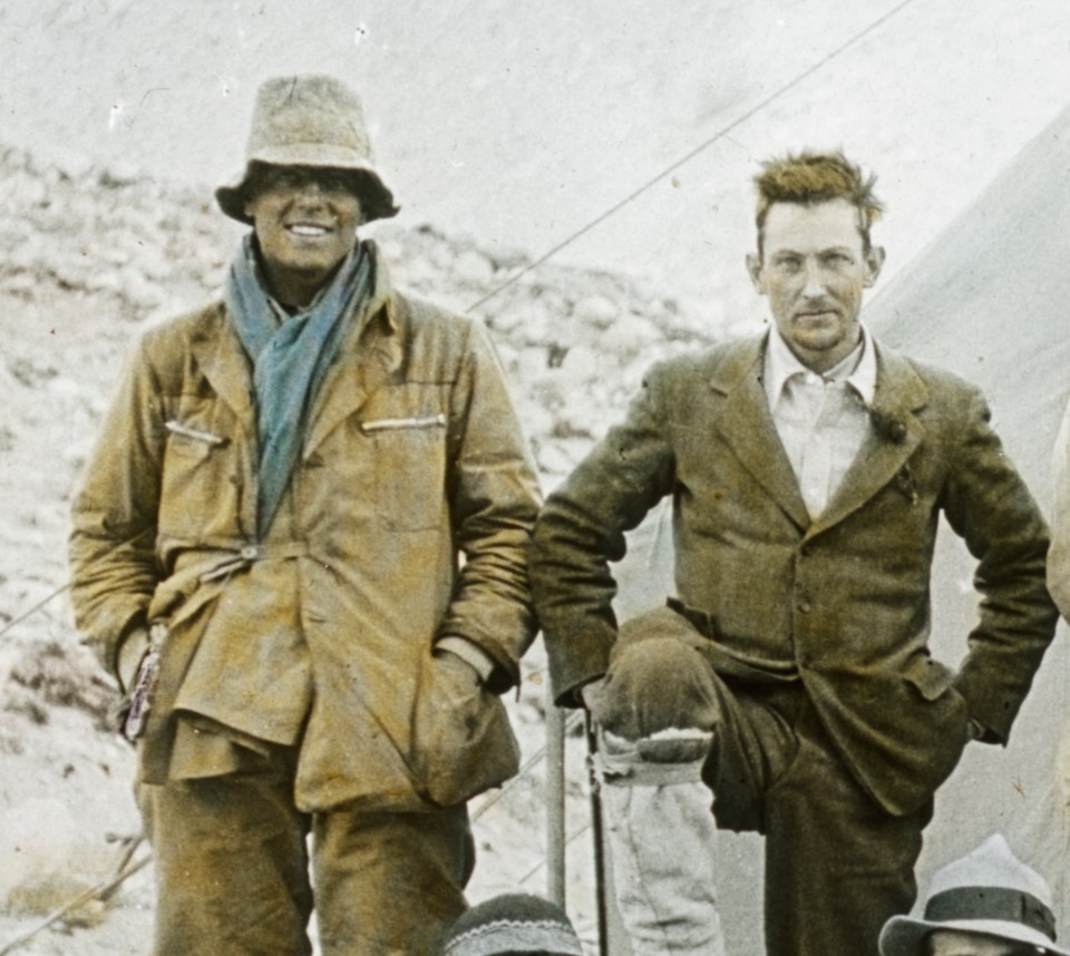two men standing next to each other with their hands in their pockets