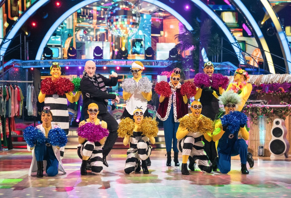 a group of people dressed in minions costumes holding pom poms