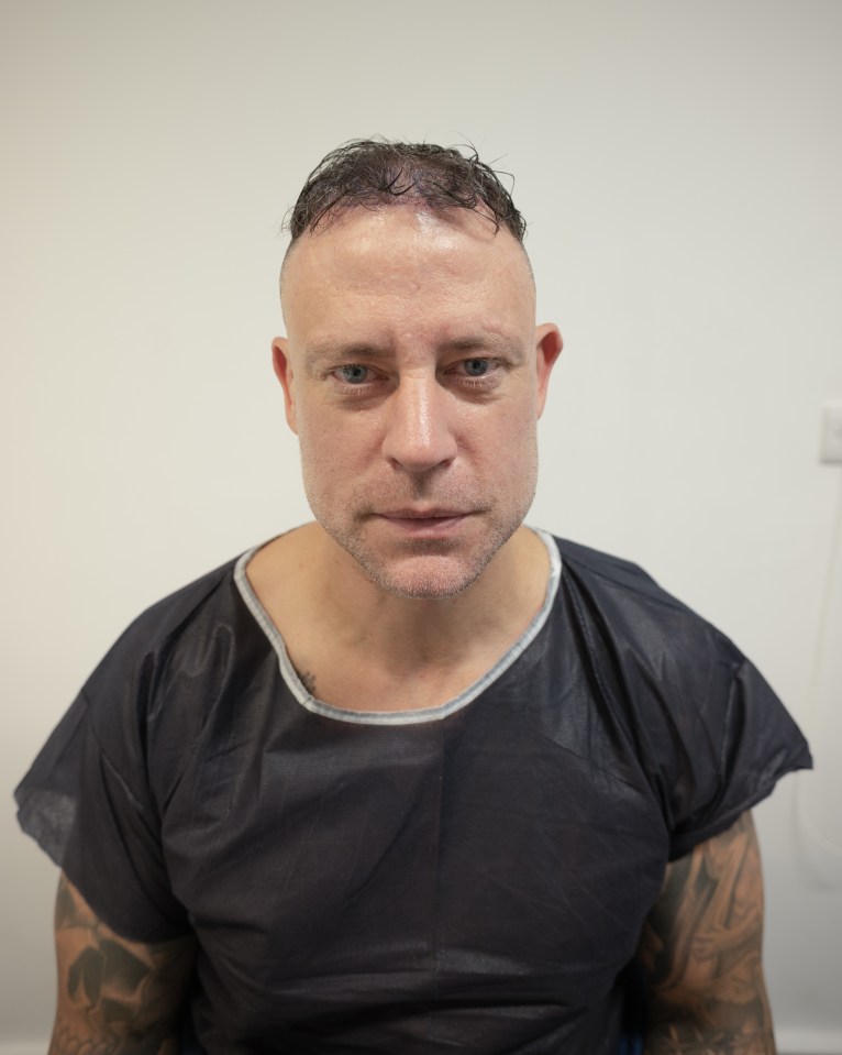 a man with a tattoo on his arm is wearing a black shirt