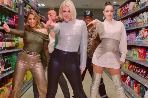 a group of people are dancing in a grocery store under a sign that says fruit juices