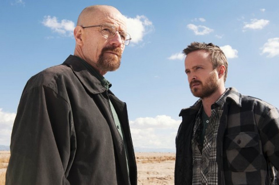 two men standing next to each other with a blue sky in the background