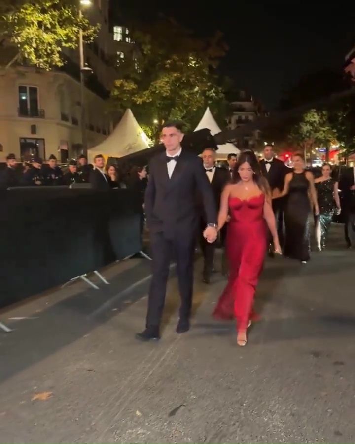 a group of people walking down a street holding hands