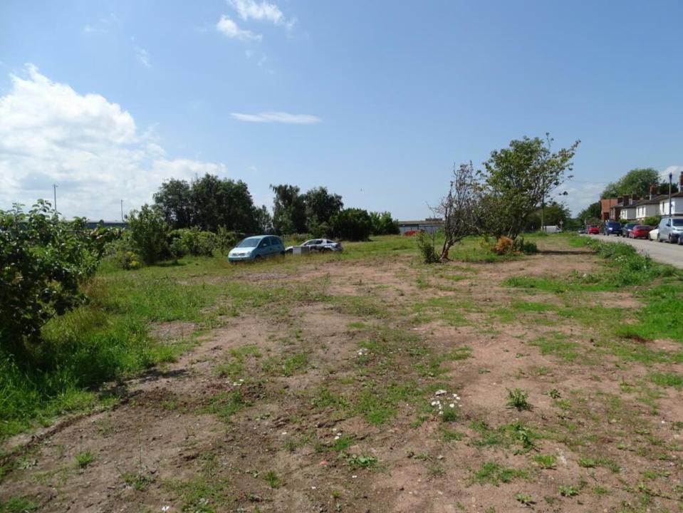 a blue car is parked in the middle of a grassy field