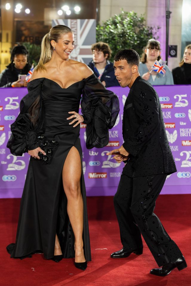 a woman in a black dress is standing next to a man in a black suit
