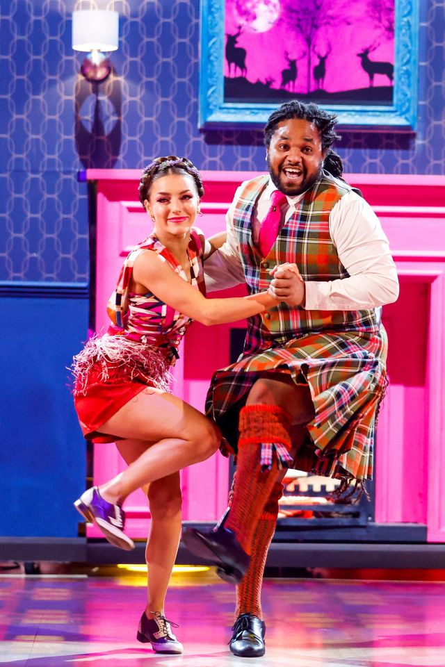 a man in a blue and yellow outfit is dancing on a stage