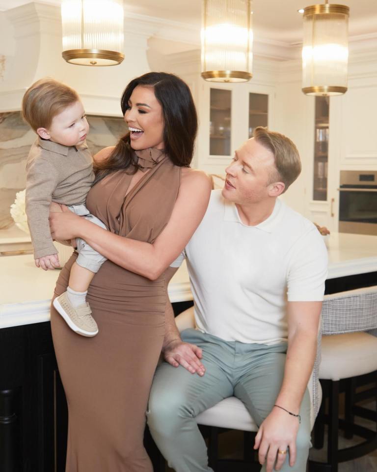 a woman in a brown dress is holding a baby