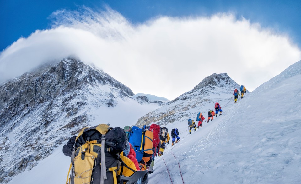 a group of people are hiking up a snowy mountain