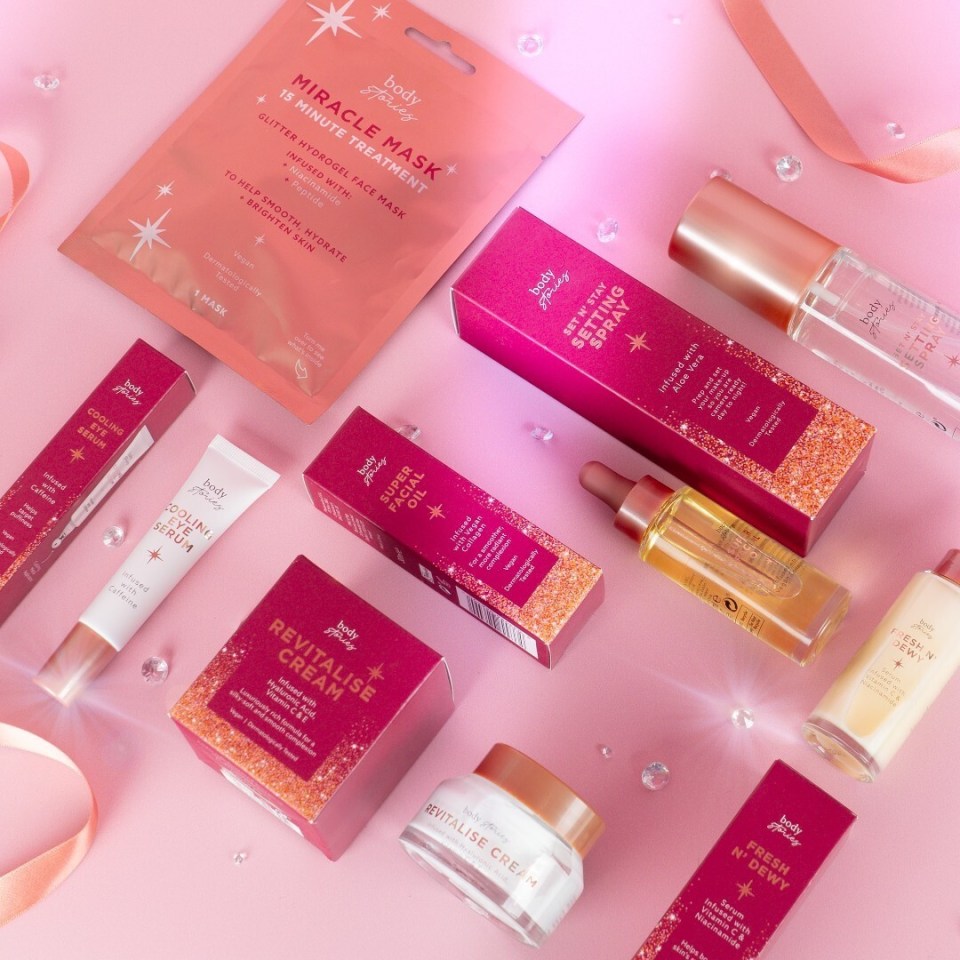 a variety of body shop products are laid out on a pink surface
