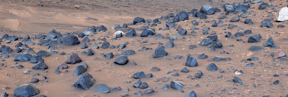 a pile of rocks on a sandy surface