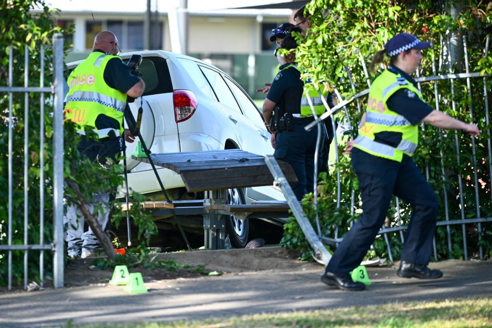 a group of police officers are standing around a white suv