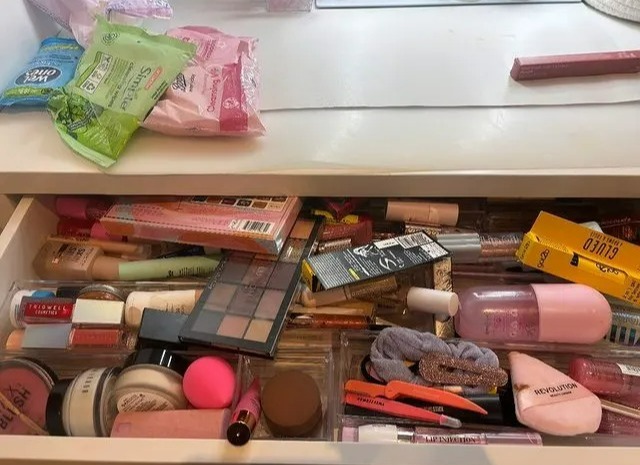 a drawer filled with a variety of makeup products including maybelline mascara