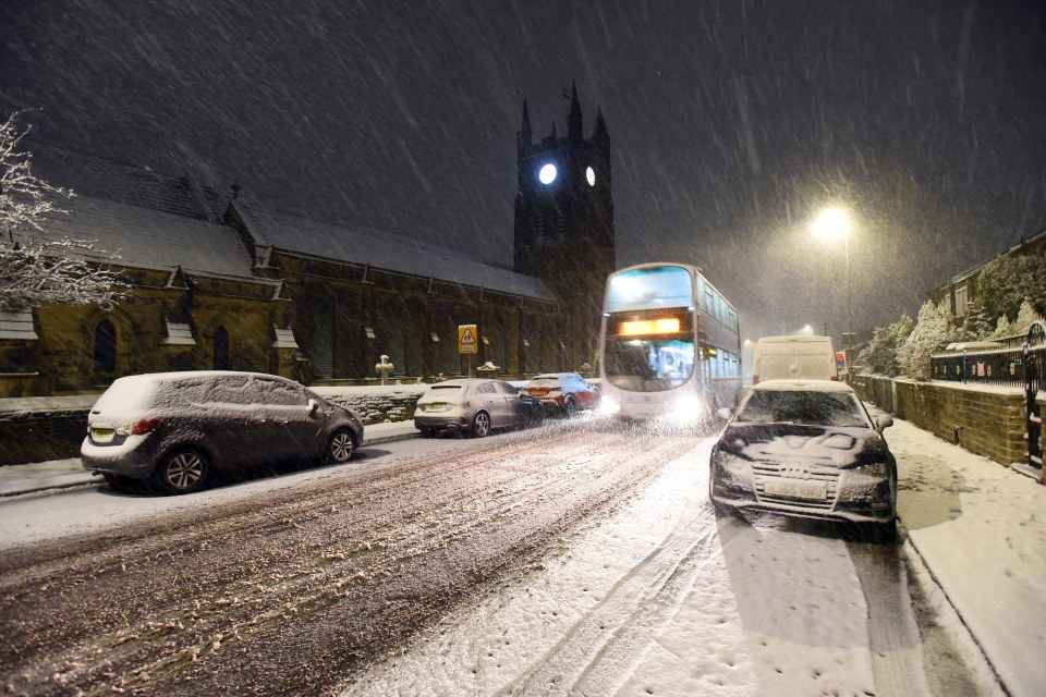 a double decker bus is driving down a snowy street