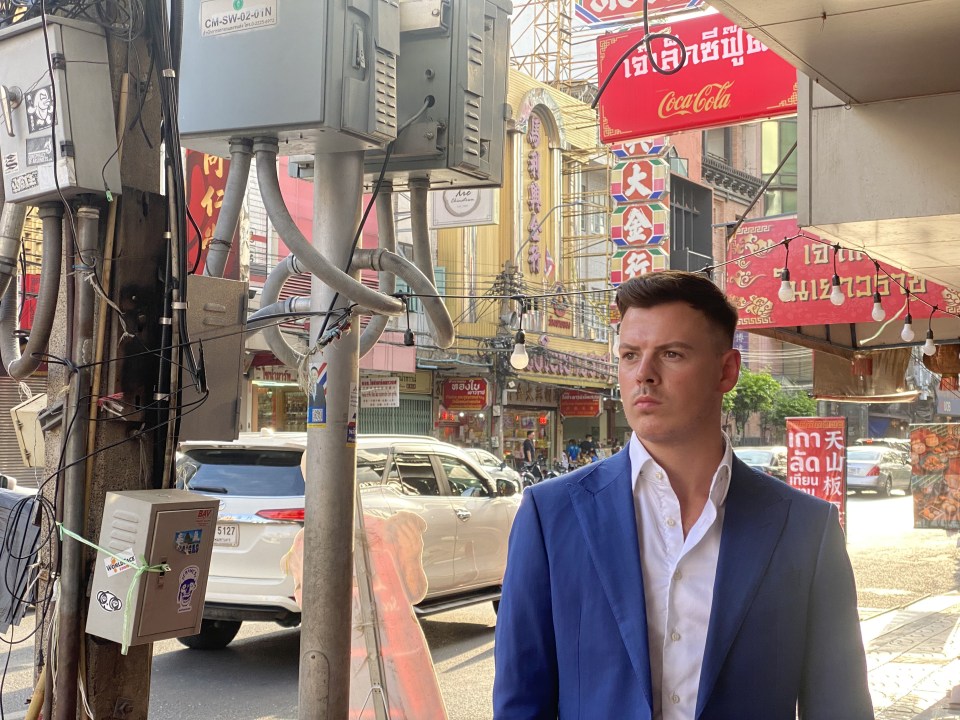 a man stands in front of a coca cola sign