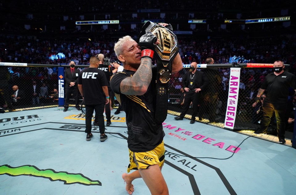 a fighter holds up his ufc heavyweight championship belt