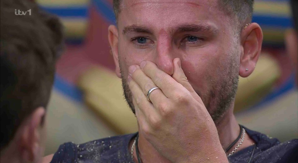 a man with a ring on his finger is crying on tv