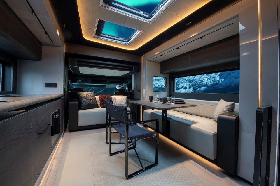 a living room with a table and chairs and a skylight