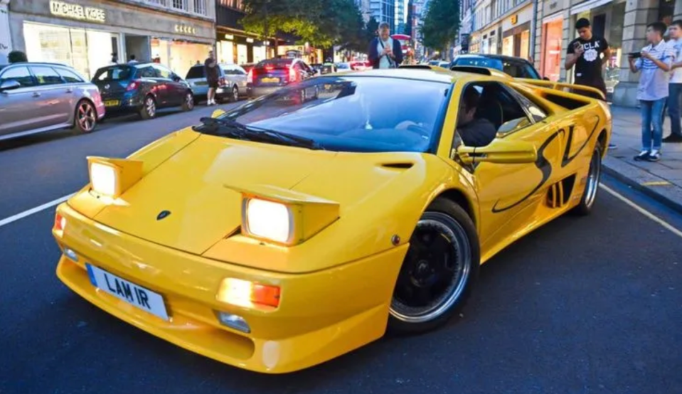a yellow sports car with a license plate that says lan ir