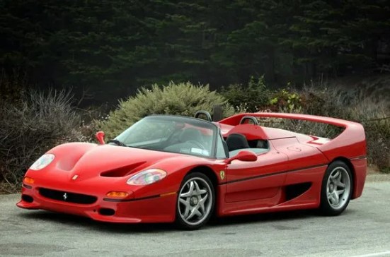 a red ferrari sports car is parked on the side of the road