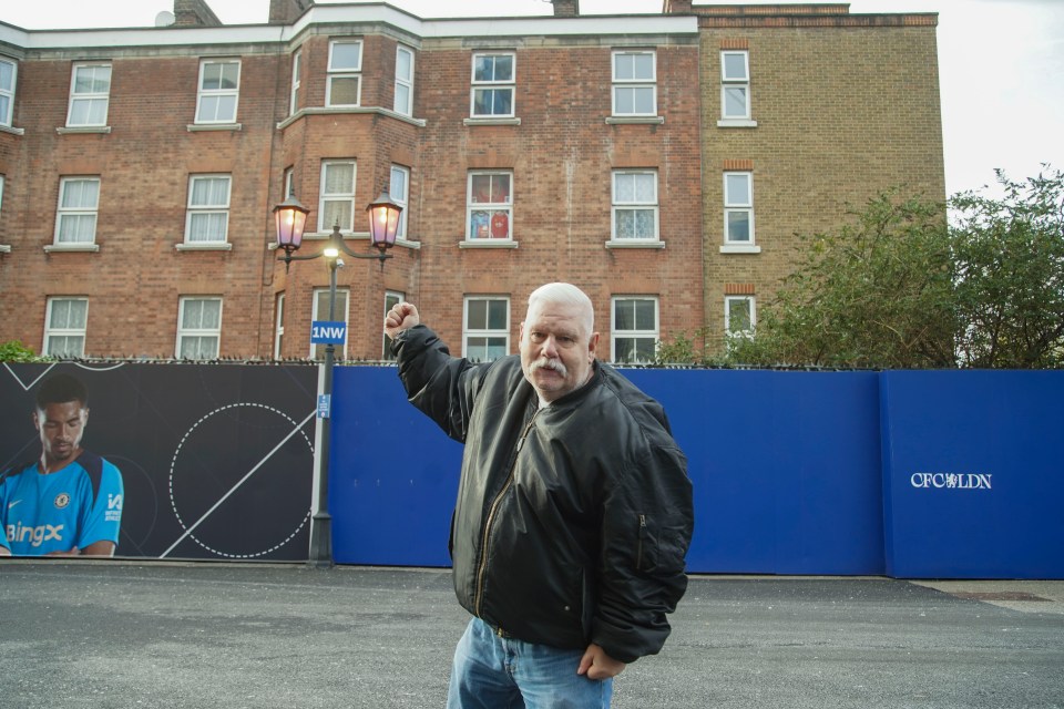 a man stands in front of a fence that says crowley on it