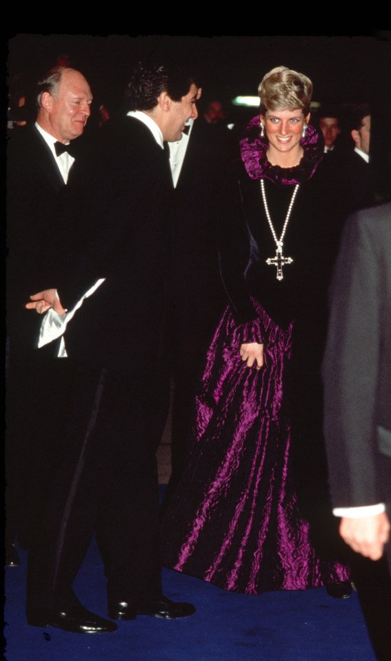 a woman in a purple dress with a cross necklace