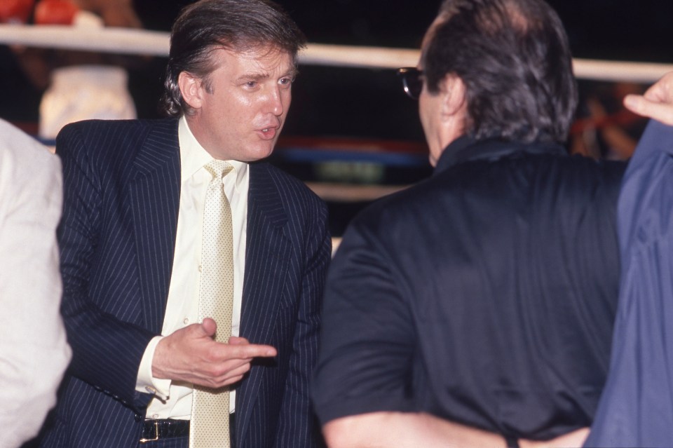 a man in a suit and tie is talking to another man