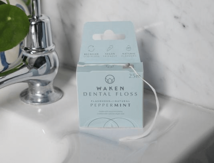 a box of waken dental floss sits next to a sink