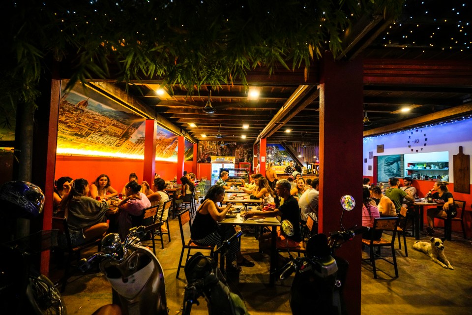 a group of people are sitting at tables in a restaurant