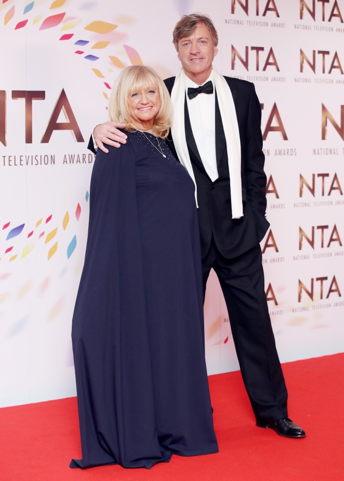 a man and a woman pose on a red carpet at the national television awards