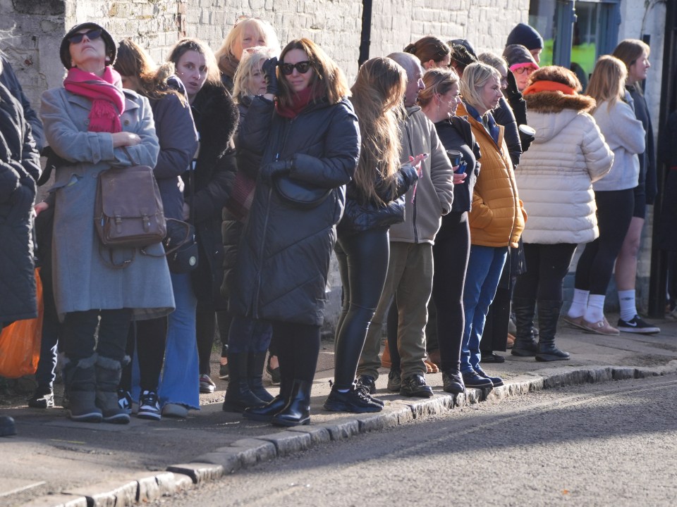 a group of people standing on the side of the road