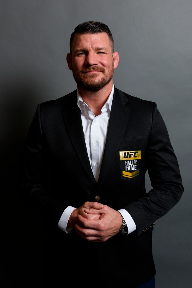 a man in a suit has a patch on his jacket that says ufc hall of fame