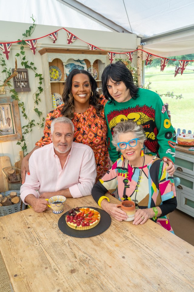 a group of people sitting at a table with a cake on it