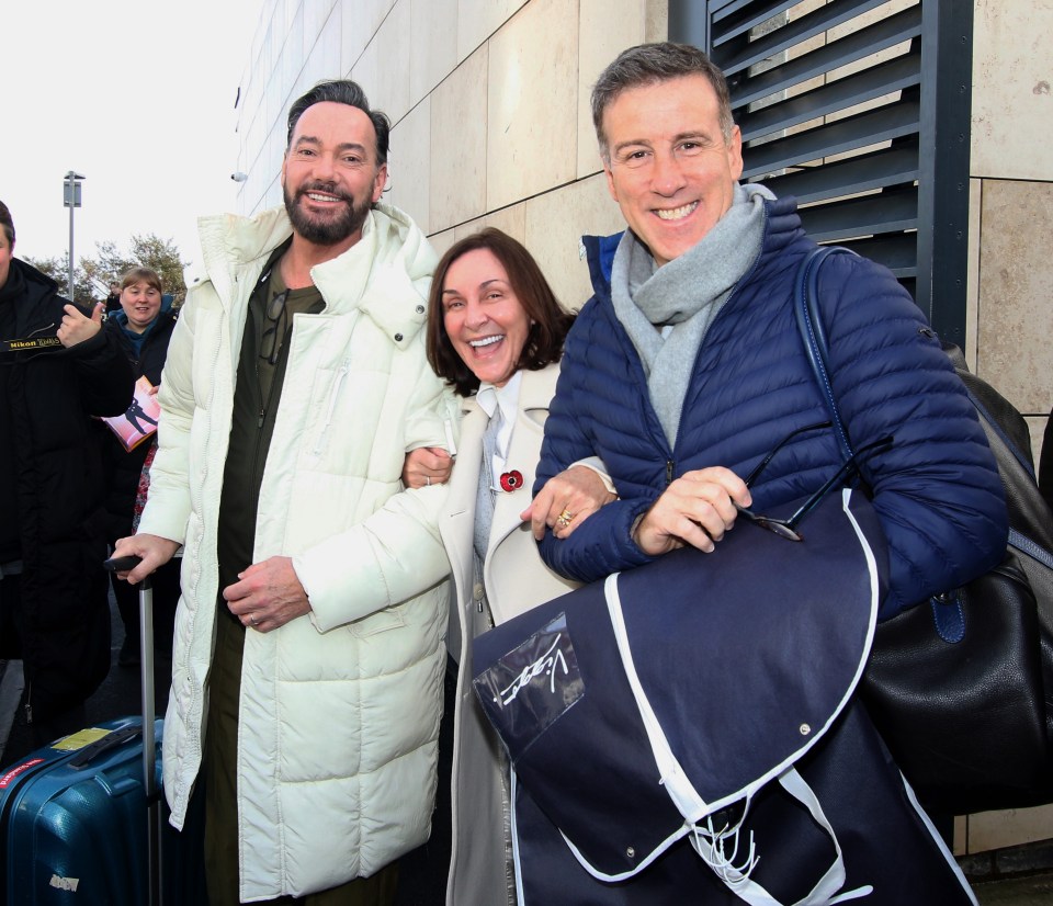 a man in a blue jacket holds a bag that says ' lacoste ' on it