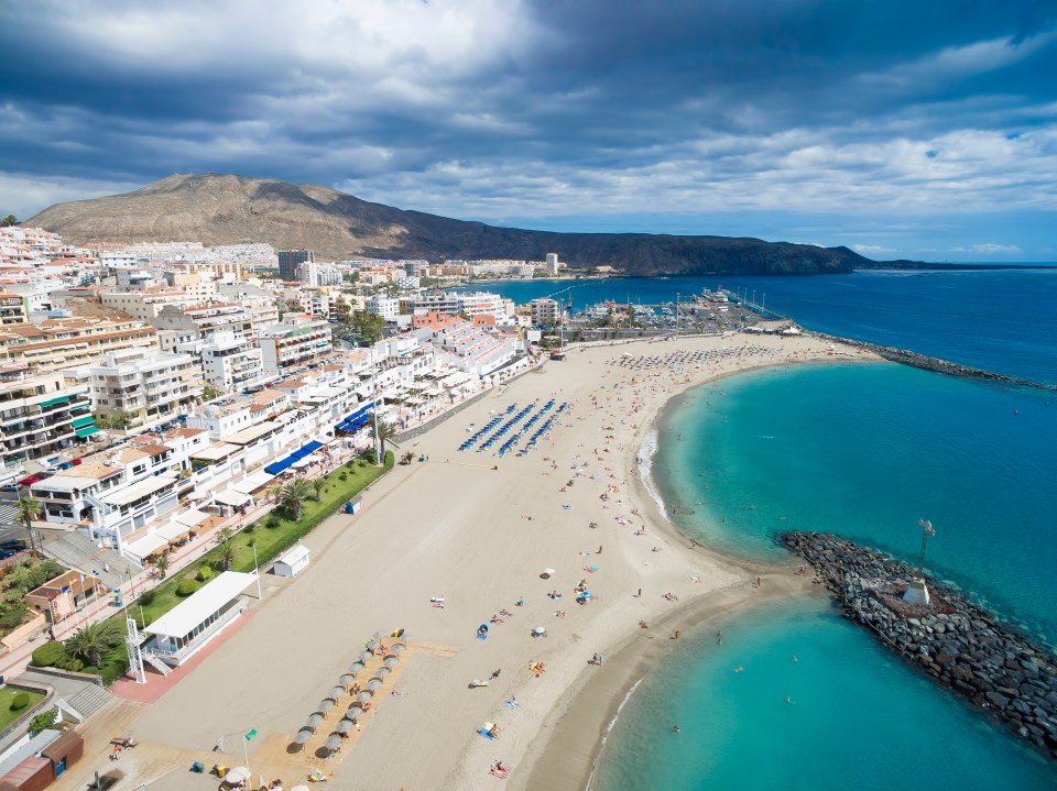 an aerial view of a beach with a city in the background